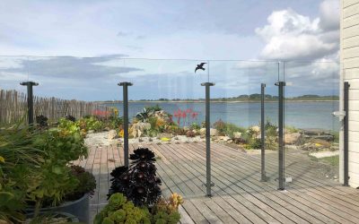 Pare-vent en verre sans cadre & portillon sur terrasse en bois bord de mer.