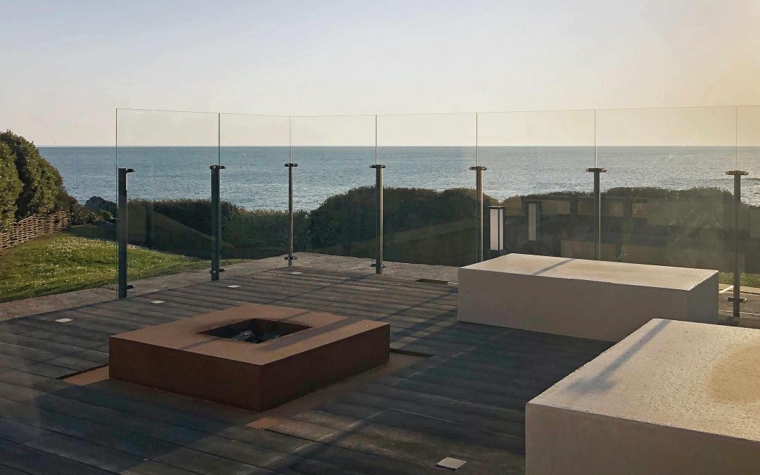 Pare-vent en verre sans cadre Menoral™ autour d’une terrasse en résine minérale en bord de mer au Croisic.