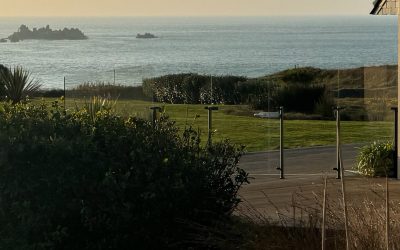 Pare-vent et portillon en verre Menoral™ sur terrasse bois exotique.