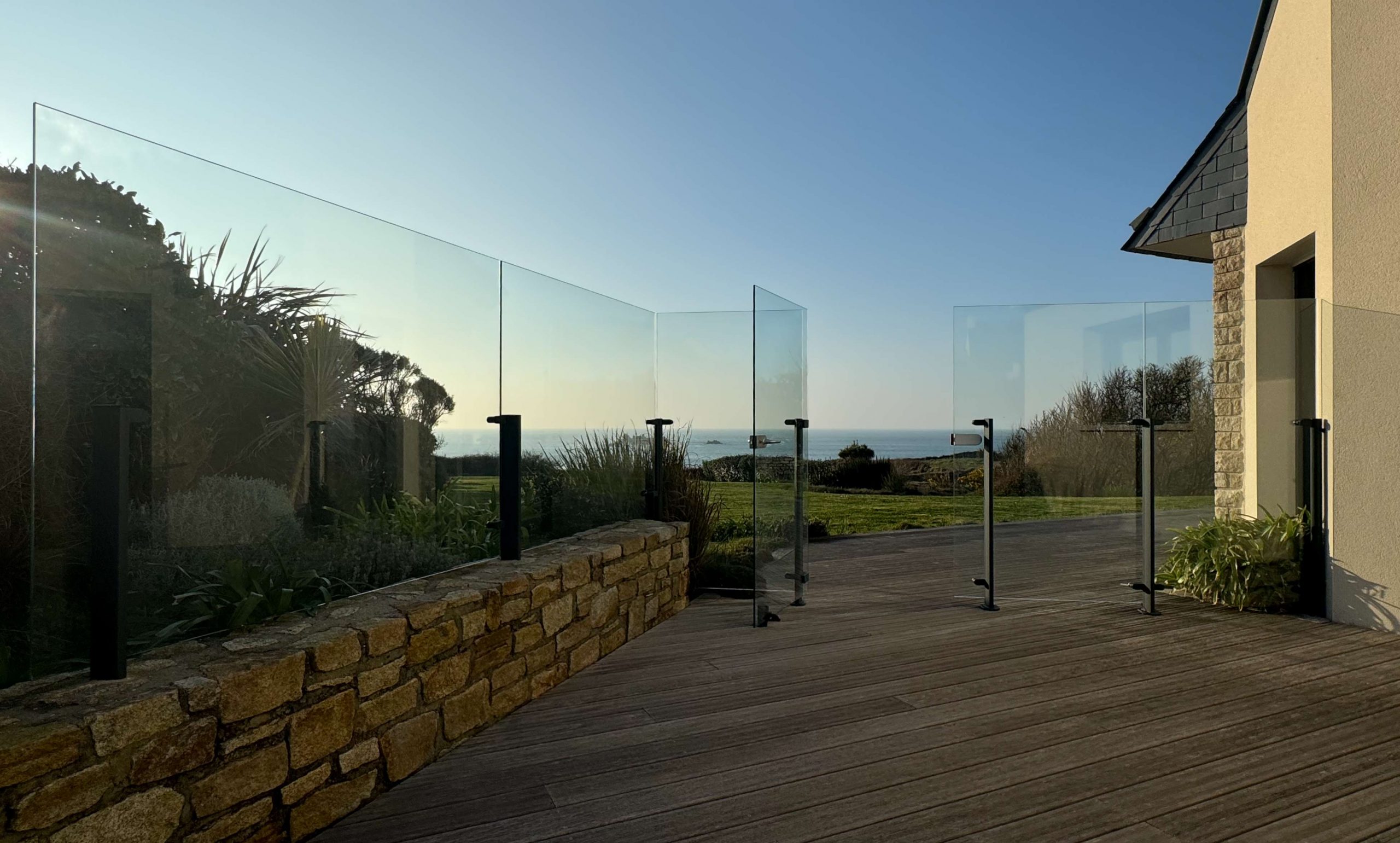 Pare-vent et portillon en verre sur mesure Menoral pour terrasse, protection contre le vent, réalisation dans le Finistère en Bretagne.